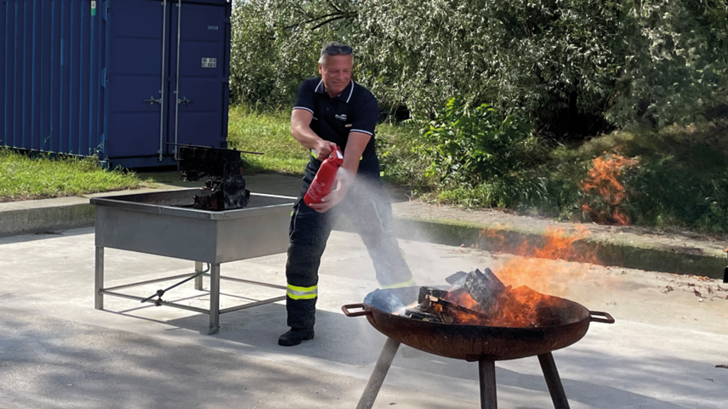 Photo d'un homme éteignant un petit feu